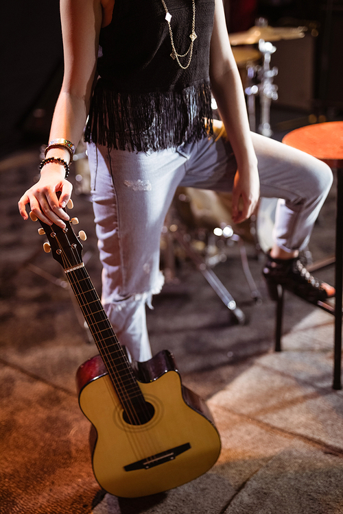 Low section of woman with guitar at nightclub