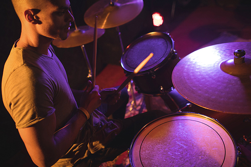 High angle view of drummer playing in illuminated nightclub