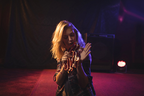Young female musician playing tambourine in nightclub