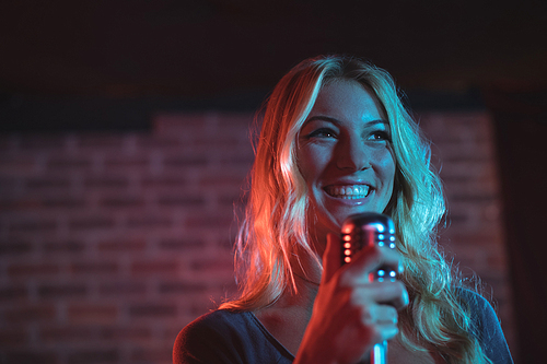 Cheerful female singer performing at music concert