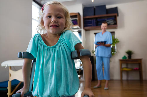 Portrait of smiling girl with crutches in clinic