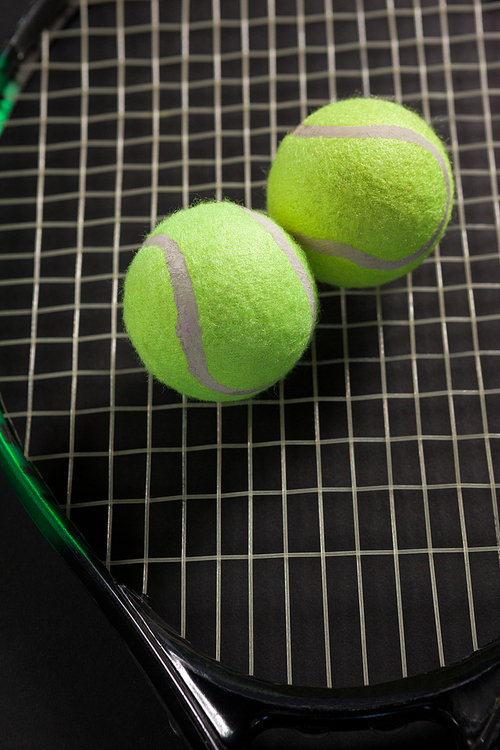 High angle view of tennis balls on racket against black background