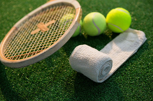 Close up of napkin with tennis balls and racket on field