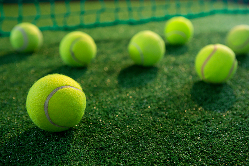 Close up of tennis balls on court by net
