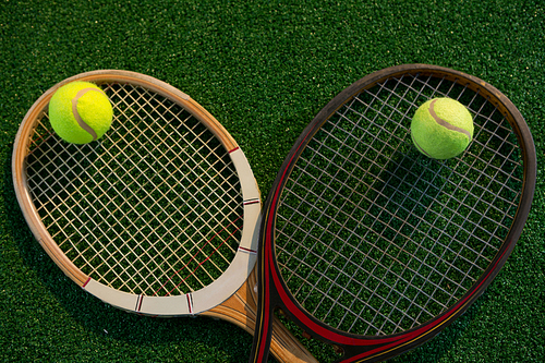Overhead view of tennis balls on rackets at playing field