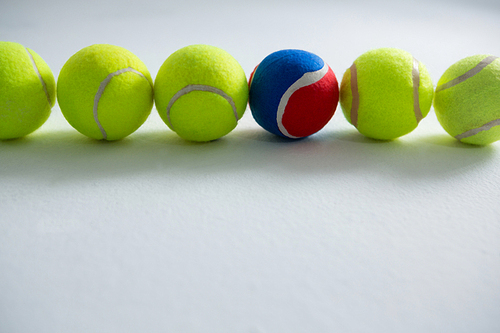 Tennis balls arranged side by side on white background