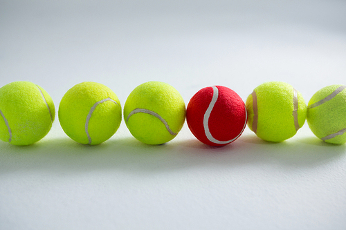 Tennis balls arranged side by side against white background