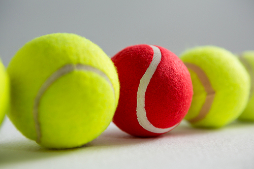 Close up of red and fluorescent tennis balls on white background