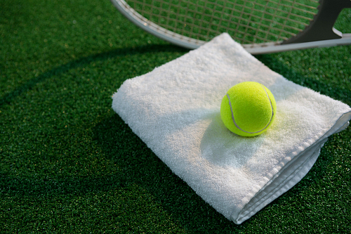 Tennis ball on napkin by racket at playing field