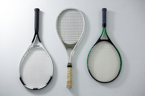 Directly above shot of metallic tennis rackets on white background