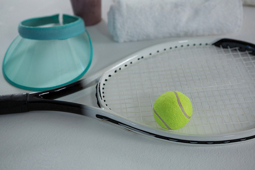 High angle view of tennis ball on racket by sun visor against white background