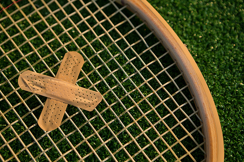 Cropped image of racket with bandage on field