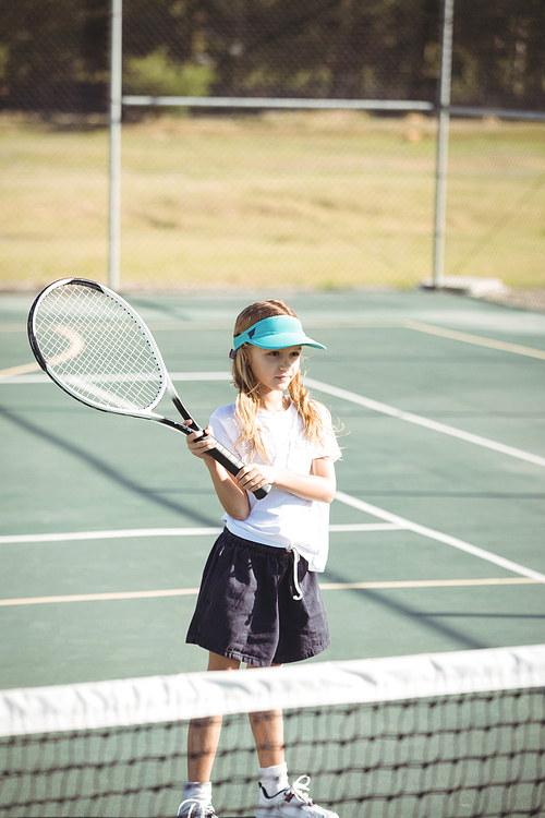 Girl playing tennis at court during sunny day