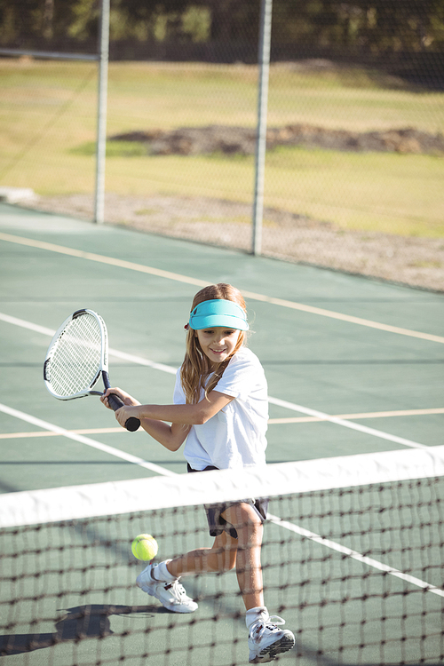 Full length of girl playing tennis on sunny day