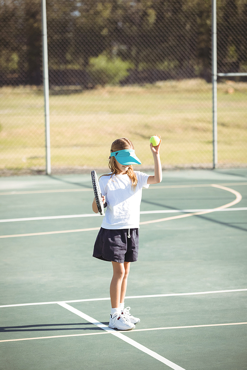 Girl playing tennis on court during sunny day