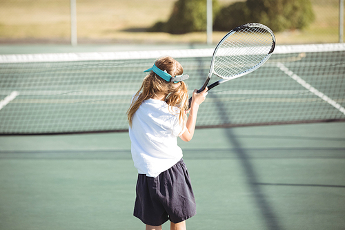 Rear view of girl playing tennis on sunny day