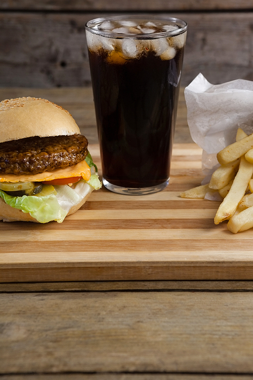 Close-up of hamburger, french fries and cold drink on table