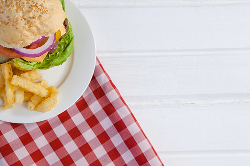 Hamburger and french fries in plate on wooden table