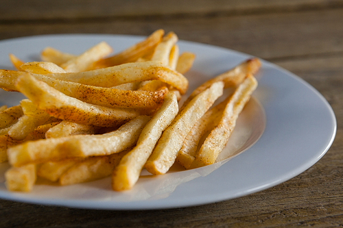 French fried chips in plate on wooden table