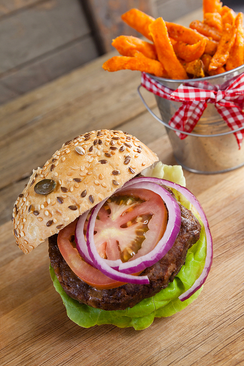 Close-up of hamburger and french fries on chopping board