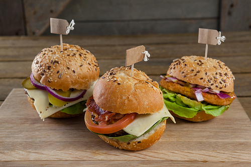 Close-up of various hamburger with tag on wooden table