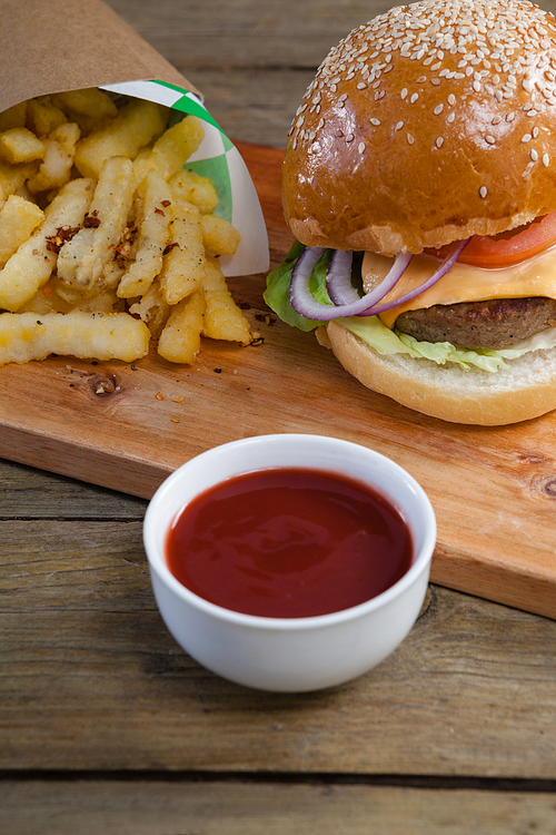 Close-up of hamburger, french fries and tomato sauce on table