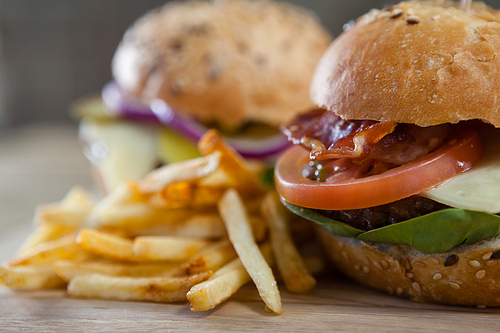 Close-up of hamburger and french fries on wooden table