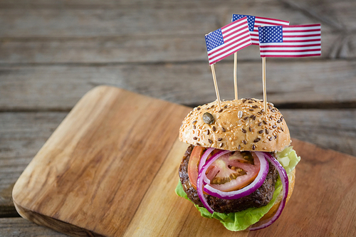 Close up of burger with american flag served on cutting board