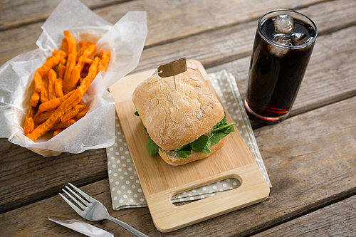 High angle veiw of burger with french fries and drink at table