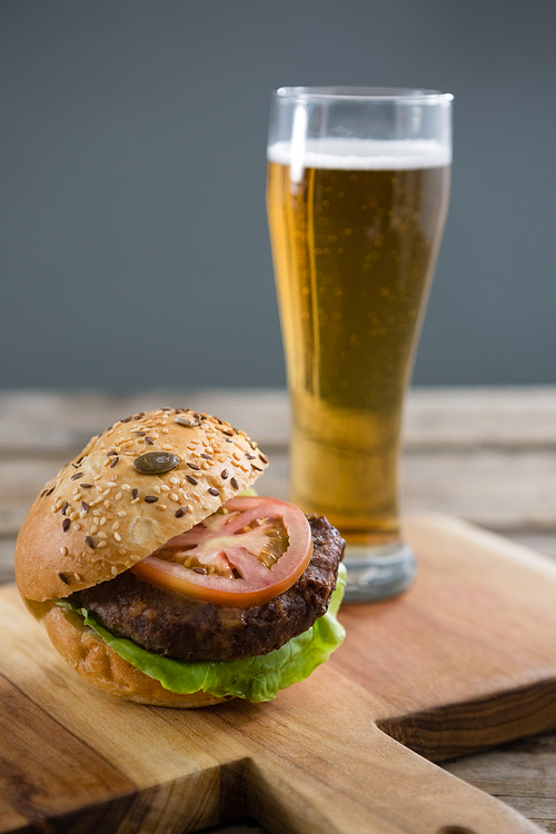 Close up of hamburger with beer on cutting board