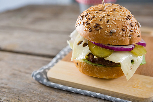 Close up of cheeseburger on cutting board