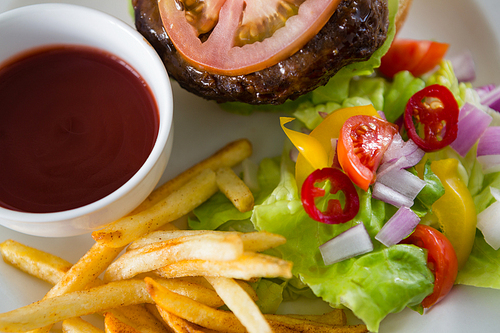 Overhead view of salad with burger and french fries in plate