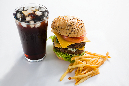 Cheeseburger and drink with French fries on white background