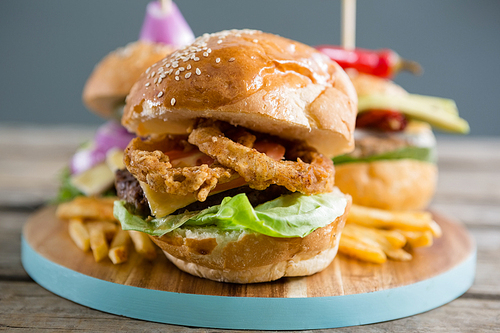 Close up of onion rings in burger on cutting board