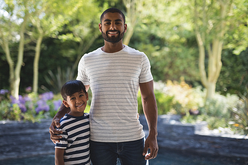 Portrait of smiling young man with his son standing at porch