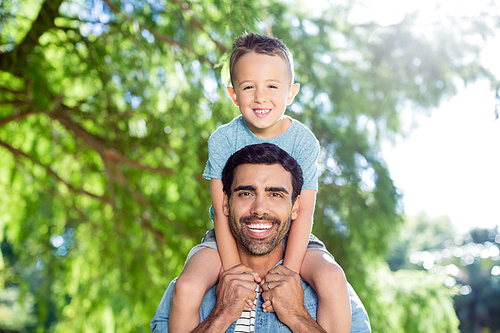 Father carrying son on his shoulders in the park