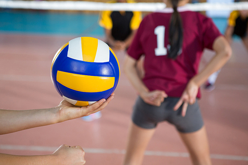 Female volleyball players playing volleyball in the court