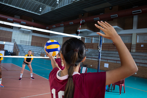 Female volleyball players playing volleyball in the court