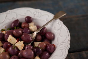 Cropped image of black olives served in plate on table