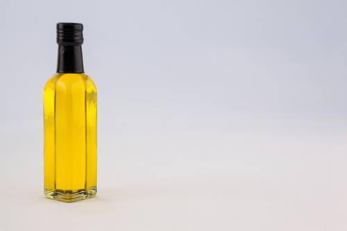 Yellow oil bottle against gray wall