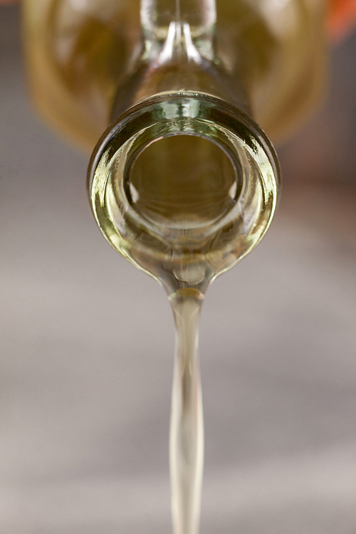 Close up of glass bottle pouring olive oil