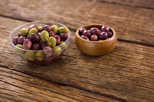 Marinated olives in bowls on wooden table
