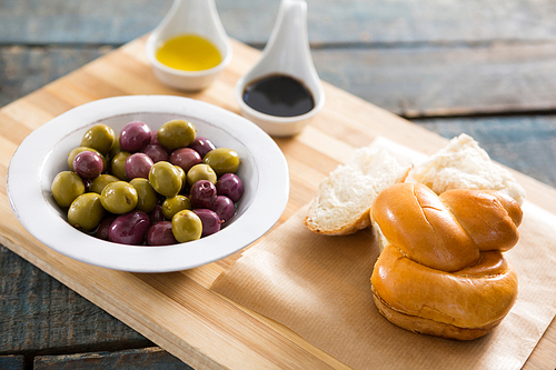 Marinated olives with bread and olive oil on chopping board