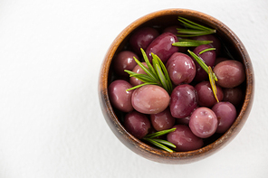 Pickled olives in wooden bowl on white background