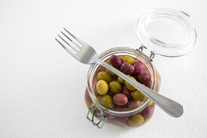 Pickled olives in jar against white background