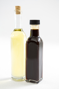 Green and purple olive oil bottles against white background