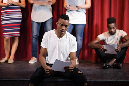 Actor reading his scripts on stage in theatre