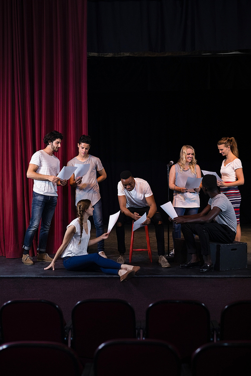 Actors reading their scripts on stage in theatre