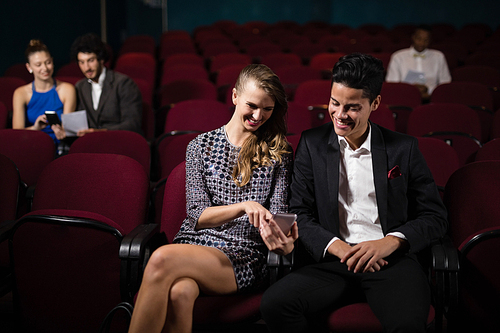 Happy couple watching movie in theatre