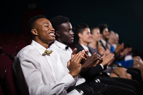 Group of people applauding in movie theatre